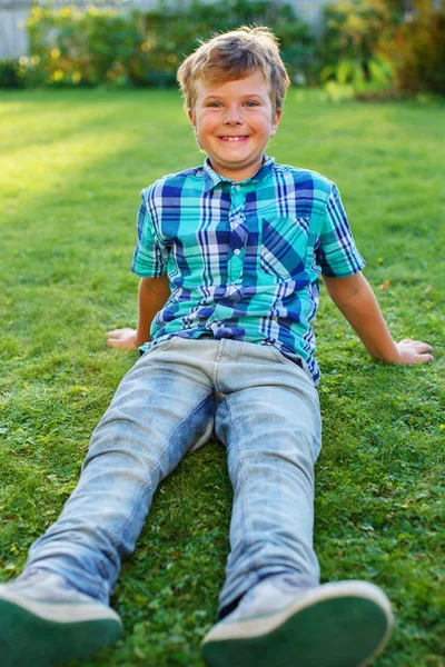 Bir çayır üzerinde oturan genç çocuk — Stok fotoğraf