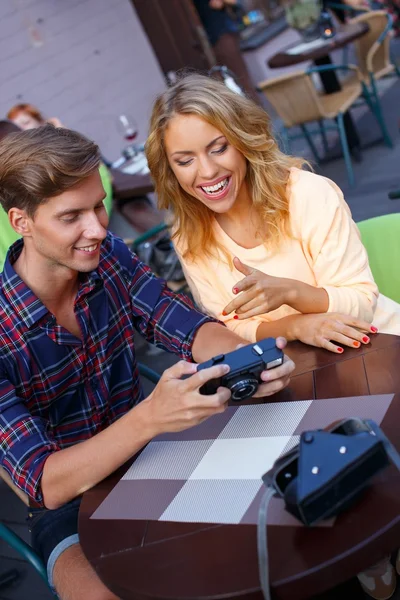 Jovem casal assistindo fotos na câmera de fotos — Fotografia de Stock