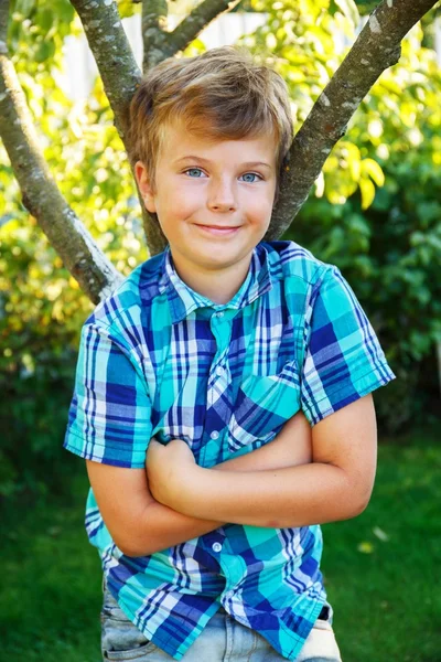 Młody chłopak stojący w pobliżu drzewa — Zdjęcie stockowe
