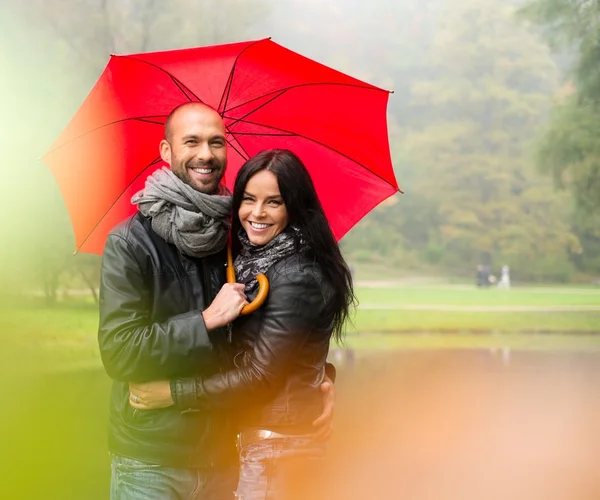 Szczęśliwa para średnim wieku z parasolem na zewnątrz na piękny deszczowy, jesienny dzień — Zdjęcie stockowe