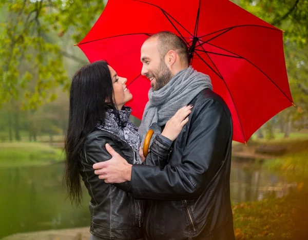 Feliz pareja de mediana edad con paraguas al aire libre en hermoso día de otoño lluvioso —  Fotos de Stock