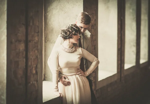 Bonito casal estilo vintage de pé perto da janela — Fotografia de Stock