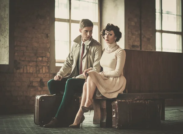 Beau couple de jeunes de style vintage avec valises sur une gare — Photo