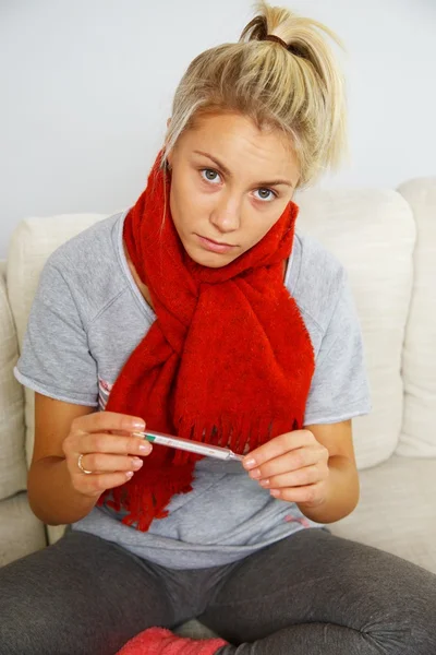 Kranke junge Frau mit Thermometer zu Hause — Stockfoto