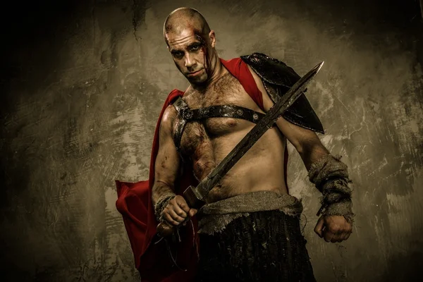 Wounded gladiator with sword covered in blood — Stock Photo, Image