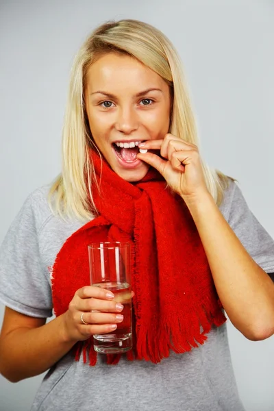 Nemocný Mladá blondýnka s prášky a sklenicí vody — Stock fotografie