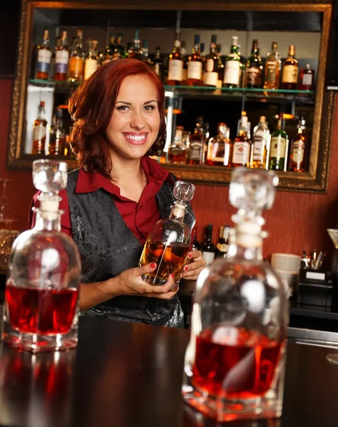 Linda empregada de bar ruiva com garrafa atrás do balcão de bar — Fotografia de Stock