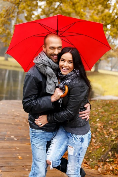 Feliz casal de meia-idade com guarda-chuva ao ar livre no belo dia chuvoso de outono — Fotografia de Stock