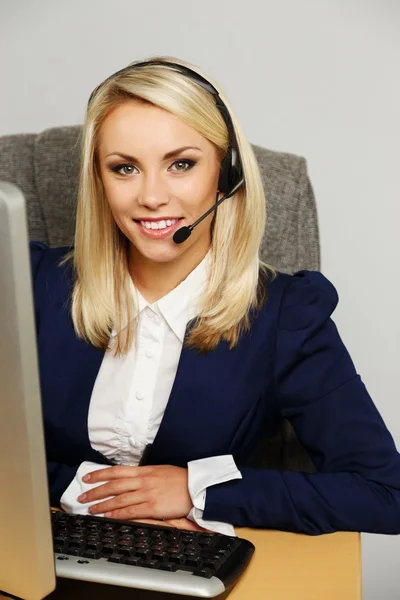 Hermosa mujer rubia de apoyo de oficina de escritorio con auriculares — Foto de Stock