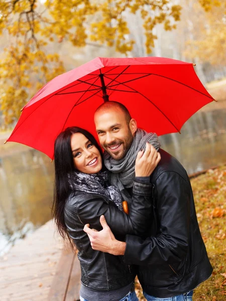 Feliz casal de meia-idade com guarda-chuva ao ar livre no belo dia chuvoso de outono — Fotografia de Stock