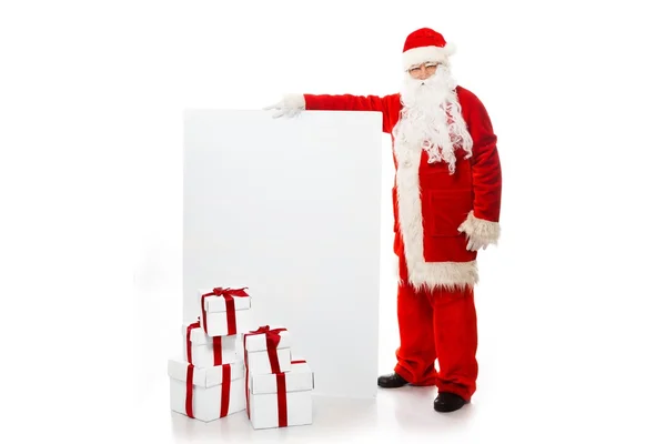 Santa Claus with many gift boxes and blank notice board — Stock Photo, Image