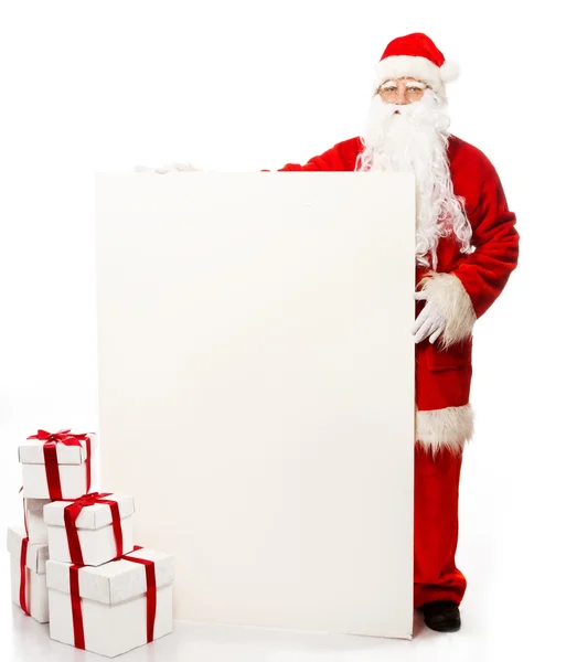 Santa Claus with many gift boxes and blank notice board — Stock Photo, Image