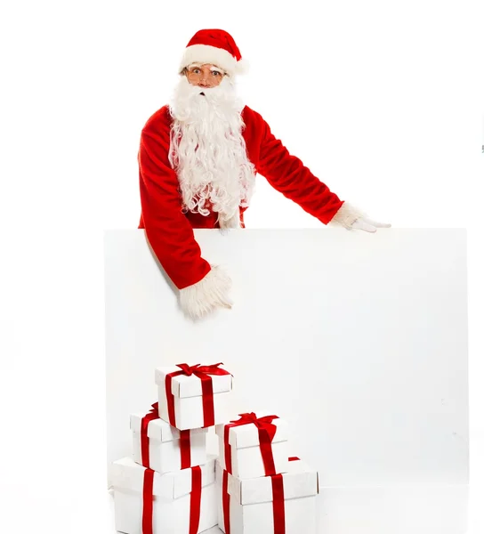 Papai Noel com muitas caixas de presente e placa de aviso em branco — Fotografia de Stock
