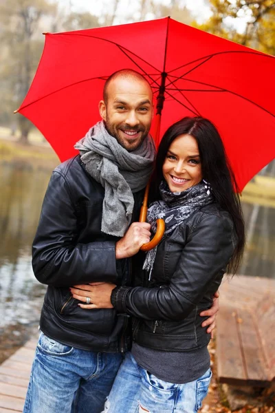 Heureux couple d'âge moyen avec parapluie à l'extérieur le beau jour d'automne pluvieux — Photo