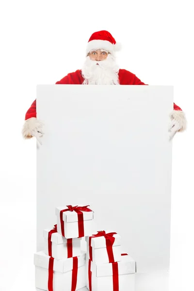Papai Noel com muitas caixas de presente e placa de aviso em branco — Fotografia de Stock