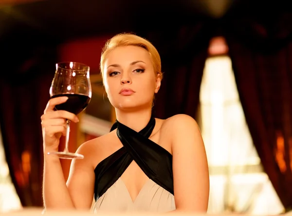 Hermosa mujer rubia en la noche con copa de vino tinto — Foto de Stock