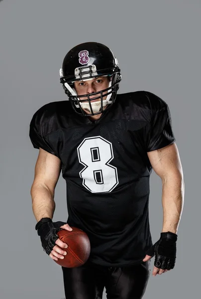 American football player with ball wearing helmet and jersey — Stock Photo, Image