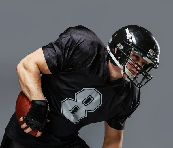 Jogador de futebol americano com bola usando capacete e camisa — Fotografia de Stock