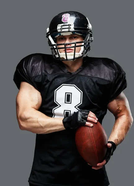 American football player with ball wearing helmet and jersey — Stock Photo, Image