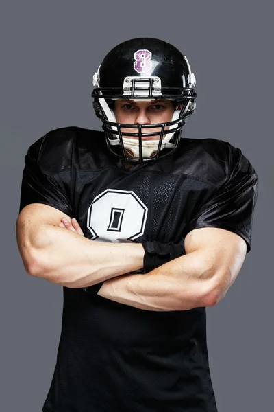 Giocatore di football americano indossando casco e maglia nera con numero — Foto Stock