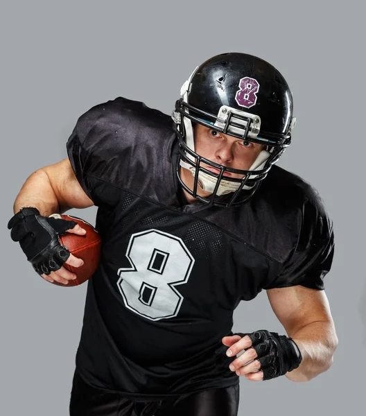 Jugador de fútbol americano con pelota usando casco y jersey — Foto de Stock