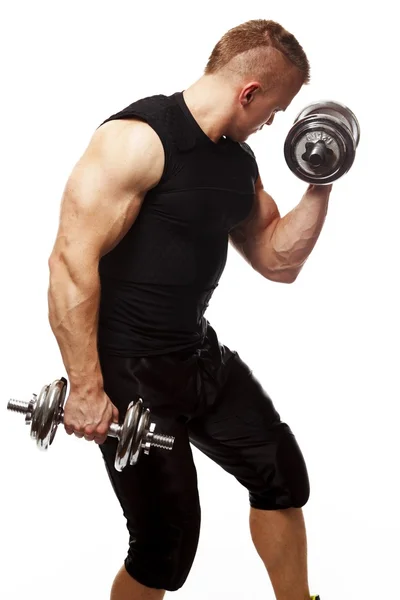 Handsome young muscular man exercising with dumbbells — Stock Photo, Image