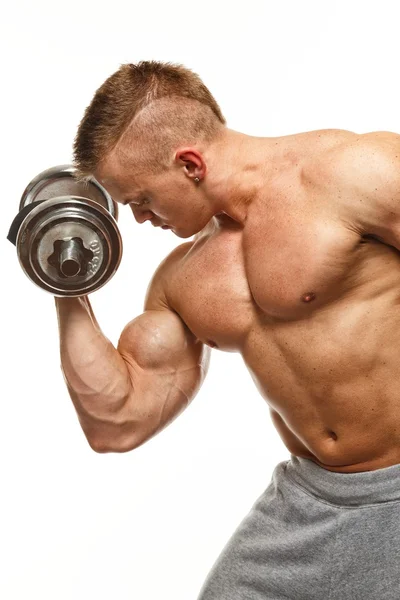 Handsome young muscular man exercising with dumbbells — Stock Photo, Image