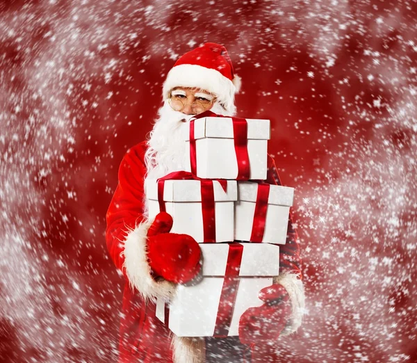 Santa Claus with gift boxes in snowstorm — Stock Photo, Image