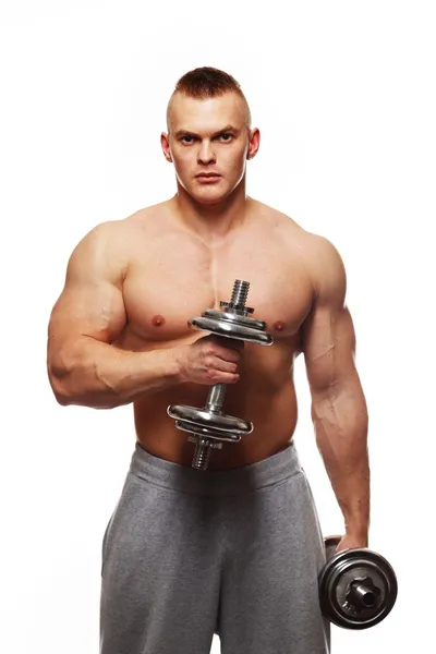 Schöner junger muskulöser Mann, der mit Hanteln trainiert — Stockfoto
