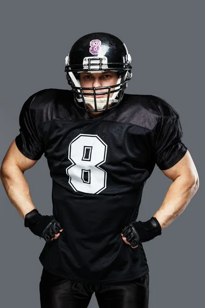 Jogador de futebol americano usando capacete e camisa preta com número — Fotografia de Stock