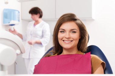 Young brunette woman with beautiful smile visiting dentist clipart