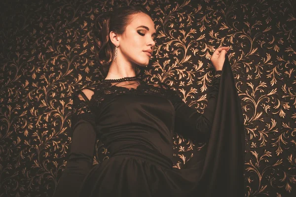 Menina bonita vestindo vestido de noite preto no interior de luxo — Fotografia de Stock