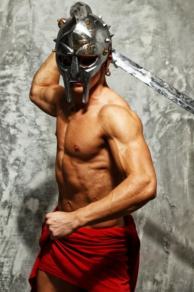 Гладіатор з м'язовим тілом з мечем і шоломом — стокове фото