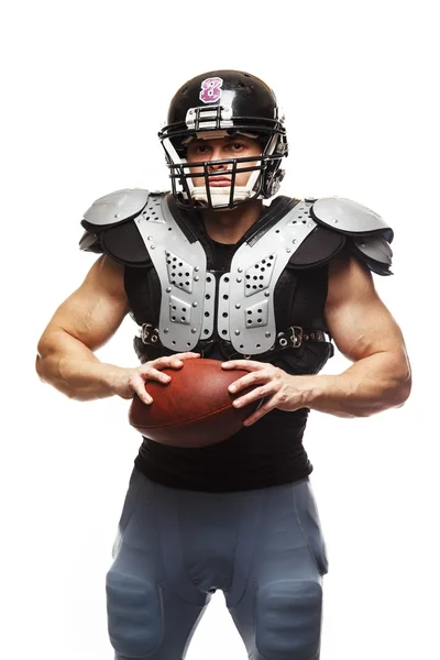 Jogador de futebol americano com bola usando capacete e escudos de proteção — Fotografia de Stock