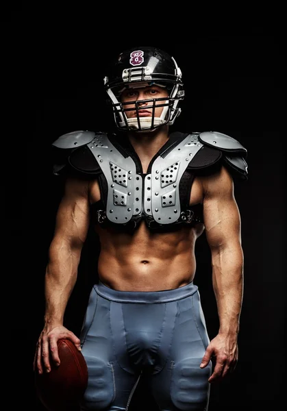 American football player with ball wearing helmet and protective shields — Stock Photo, Image