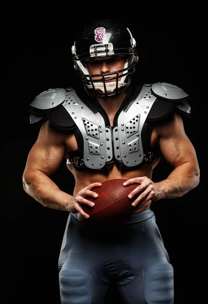 Amerikansk fotbollsspelare med boll bär hjälm och skyddande sköldar — Stockfoto