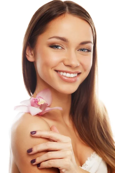 Młoda brunetka dziewczyna z pięknym uśmiechem i orchidea kwiat — Zdjęcie stockowe