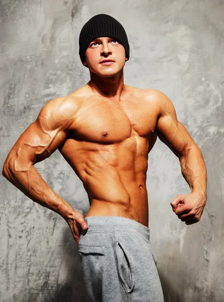 Handsome man with muscular torso in beanie hat posing — Stock Photo, Image