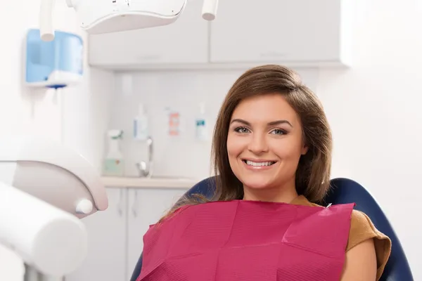 Beautiful young brunette woman visiting dentist — Stock Photo, Image