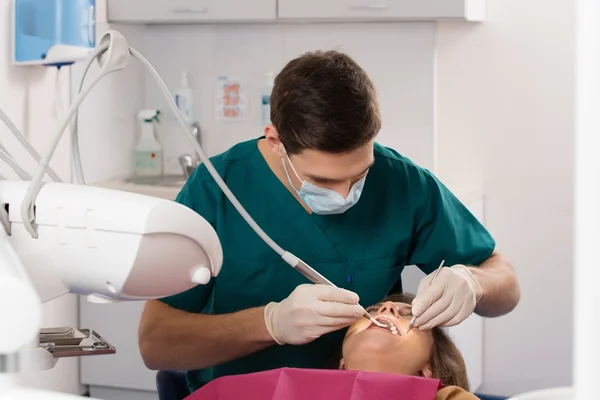 Mladá žena v mužské doktor v ordinaci zubního lékaře — Stock fotografie