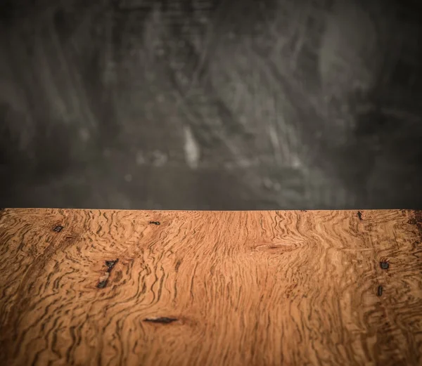 Деревянная доска против гранж-стены — стоковое фото