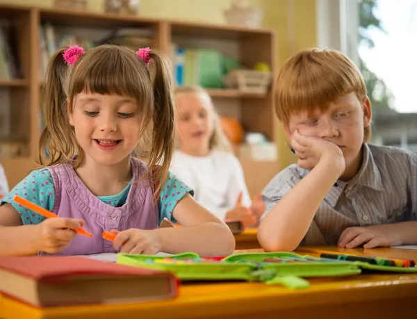 Ragazzina in una scuola con sonnolenta rossa compagno di classe — Foto Stock