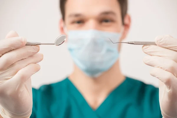 Young man dentist holding dental tools — Stock Photo, Image