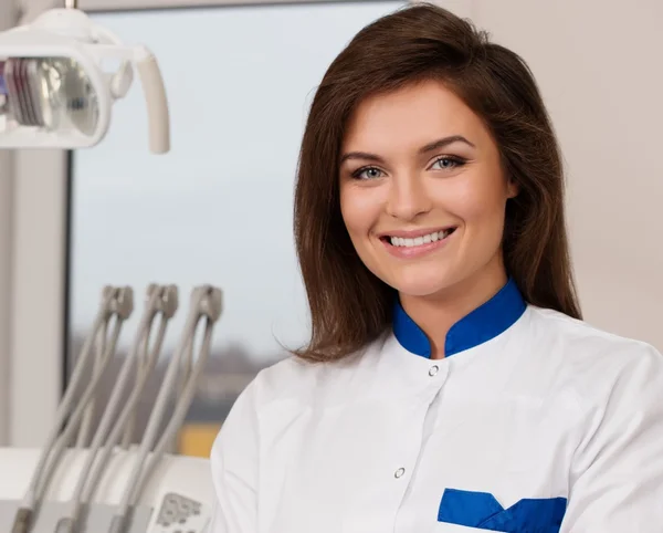 Young beautiful brunette female dentist at dentist's surgery — Stock Photo, Image