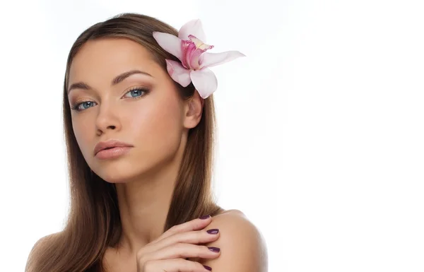 Menina morena nova com belo sorriso e flor de orquídea em seu cabelo — Fotografia de Stock