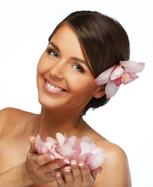 Jonge mooie brunette vrouw met orchideebloemen — Stockfoto