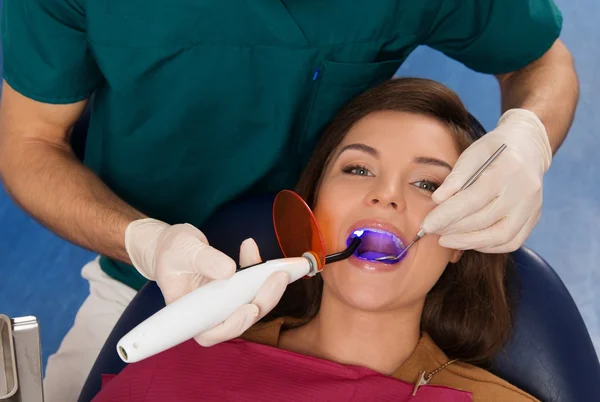 Ung kvinna Patient Stoppa behandling med Dental Uv Light Equipment — Stockfoto