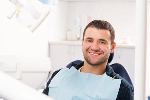 Joven sonriente en la cirugía del dentista Fotos de stock libres de derechos