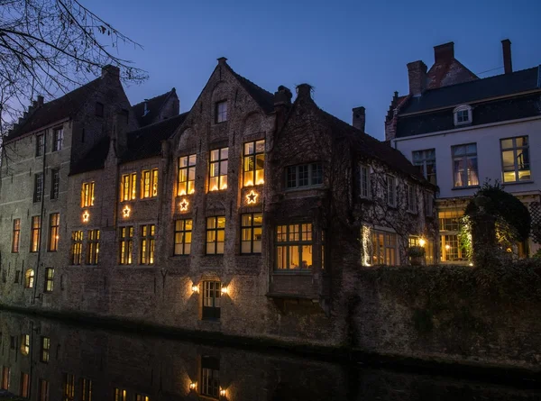 Rumah dihiasi dengan bintang-bintang Natal sepanjang kanal di malam hari di Bruges, Belgia — Stok Foto