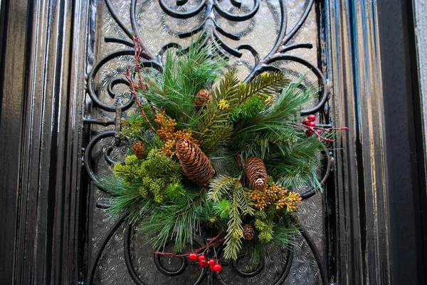 Couronne de Noël avec des cônes suspendus sur une porte — Photo